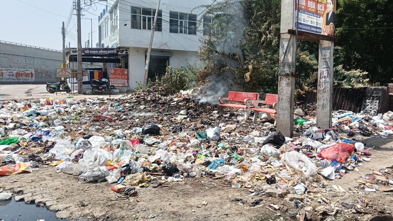 शहर के बस स्टैंड रोड के बीच कचरे में लगाई गई आग। 