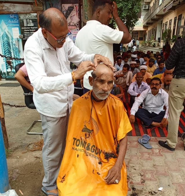 Sanitation workers express protest by shaving their heads