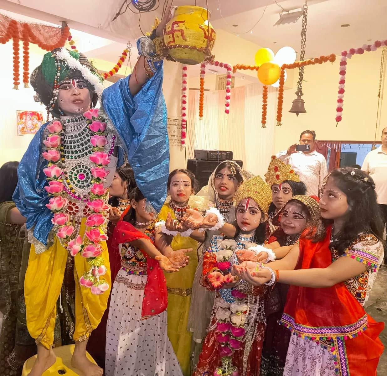 Janmashtami celebrations amidst a light drizzle; chants of "Jai Kanhaiya Lal" fill the air.