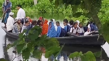 नाव में बैठकर स्कूल पहुंच रहे स्कूली बच्चे।