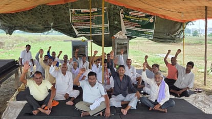 यमुना एक्सप्रेसवे प्राधिकरण के खिलाफ दयातनपुर गांव में धरना पर बैठे किसान शुक्रवार को बारिश में