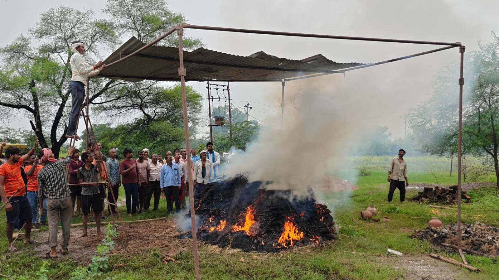 फोटो- 02मजबूरी में टिनशेट के नीचे अंतिम संस्कार करते ग्रामीण। संवाद