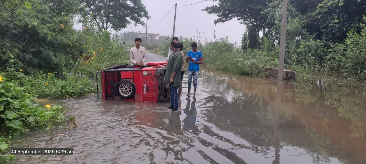 Road washed away by strong water current; e-rickshaw overturns into a pothole.