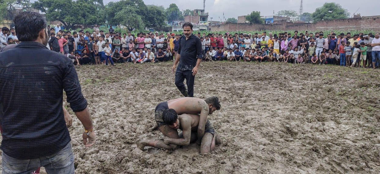 Wrestlers' bout amidst rain and mud