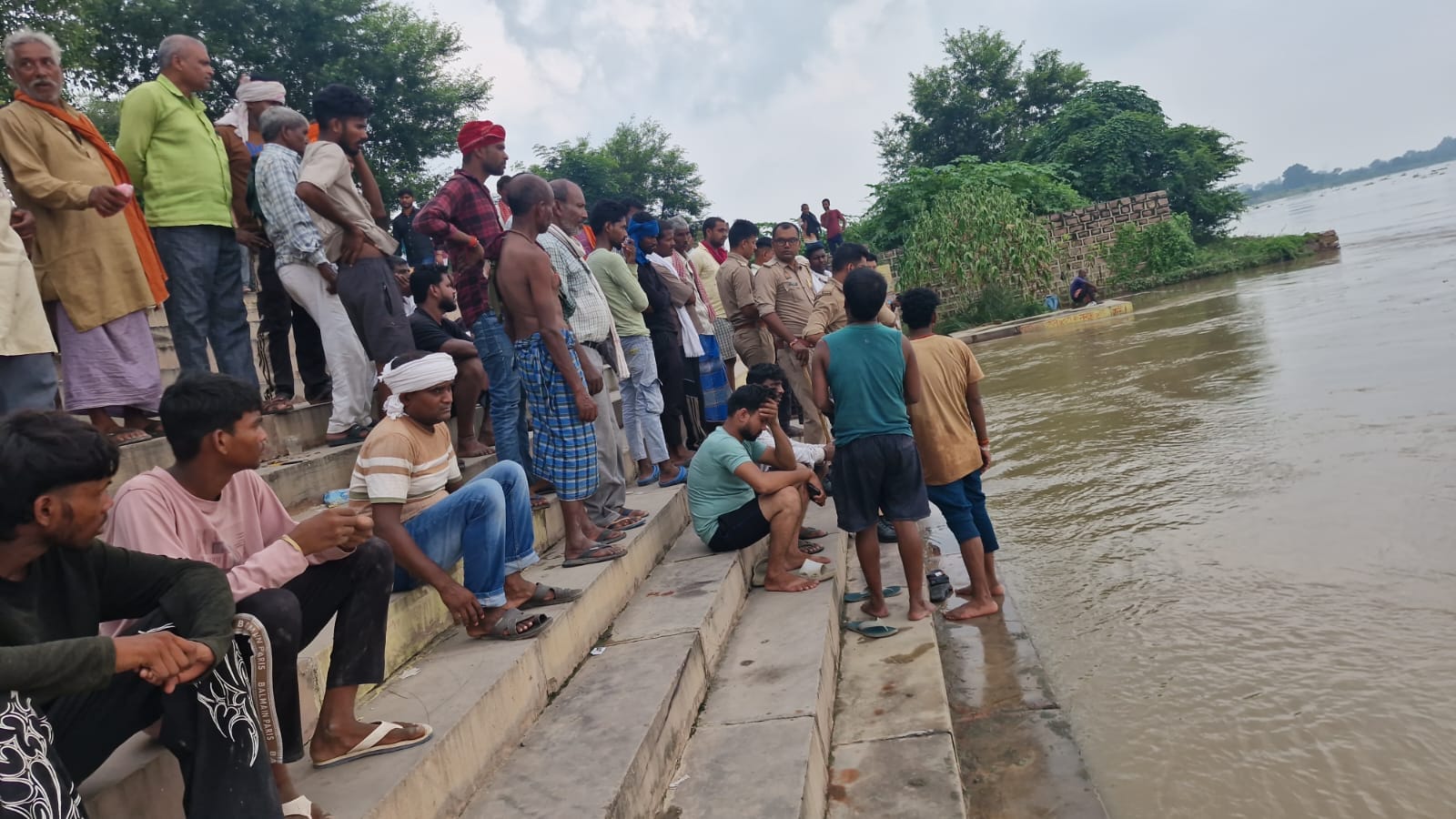 जमानिया कोतवाली क्षेत्र के बडेसर गंगा घाट पर गंगा नदी में डूबे युवक की खोजबीन करते लोग एवं मौजू