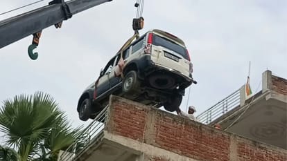 क्रेन से छत पर चढ़ाई जा रही स्कॉर्पियो।