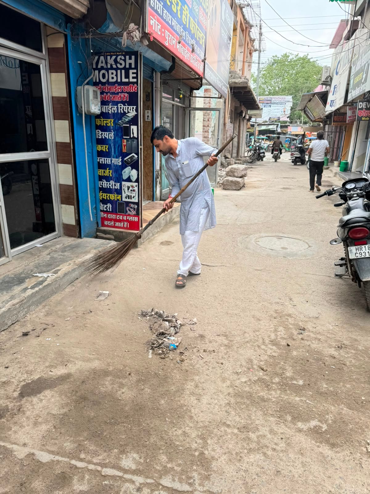 पूर्ण मार्केट में सफाई करते हुए प्रधान संदीप फोगाट। 