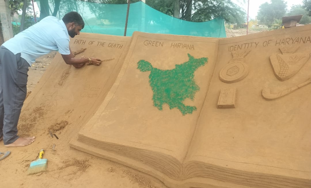 रेवाड़ी के पंडित भगवतदयाल शर्मा चौक पर अपनी सैंड आर्ट को पूरा करने में जुटे कलाकार लखनपाल।स्रोत
