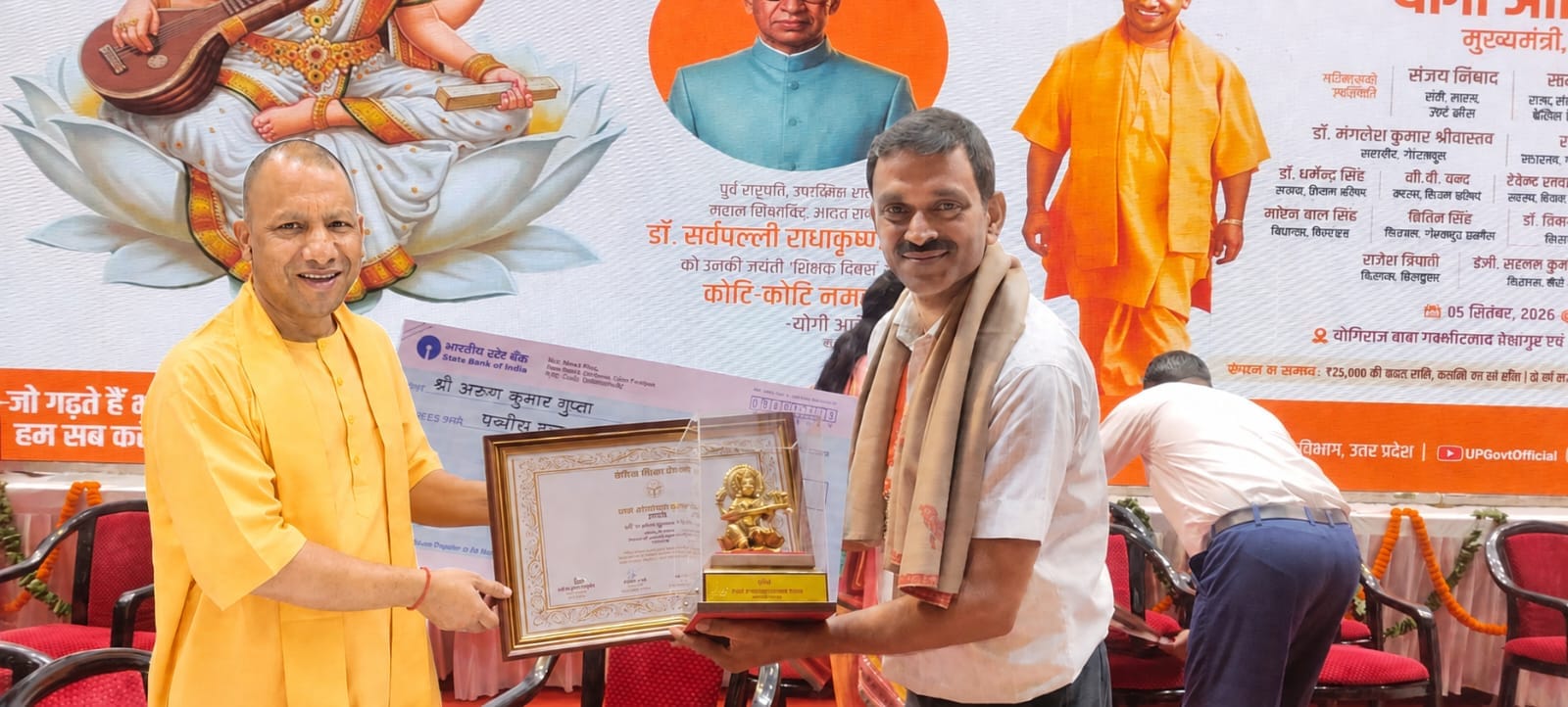 गोरखपुर में मुख्यमंत्री योगी आदित्यनाथ से सम्मान प्राप्त करते शिक्षक डॉ. अरुण गुप्ता। स्रोत : 