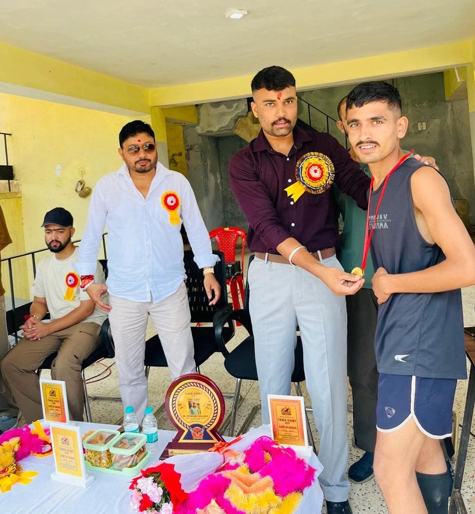 नाहन के चंबा मैदान में 1600 मीटर दौड़ के विजेताओं में से एक खिलाड़ी को सम्मानित करते मुख्यातिथि