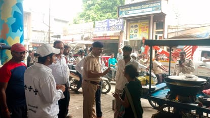 पुल के नीचे दुकानों को वाहन खड़ा न करने की हिदायत देते पुलिसकर्मी। संवाद