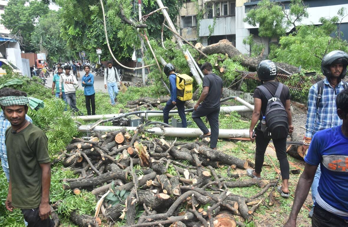 Two poles and wires snapped after a tree fell; two passersby were injured after being struck, and the power supply was disrupted for five hours.
