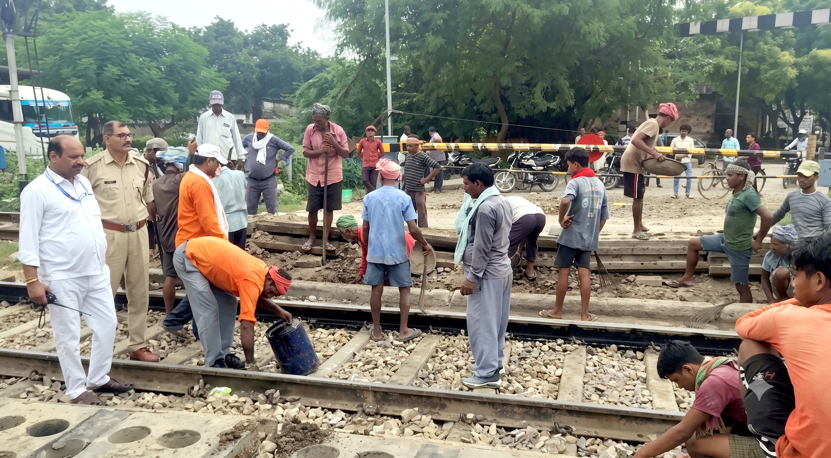 रविवार को पकरी रेलवे फाटक पर रेल पटरी की मरम्मत में लगे मजदूर। स्रोत- संवाद