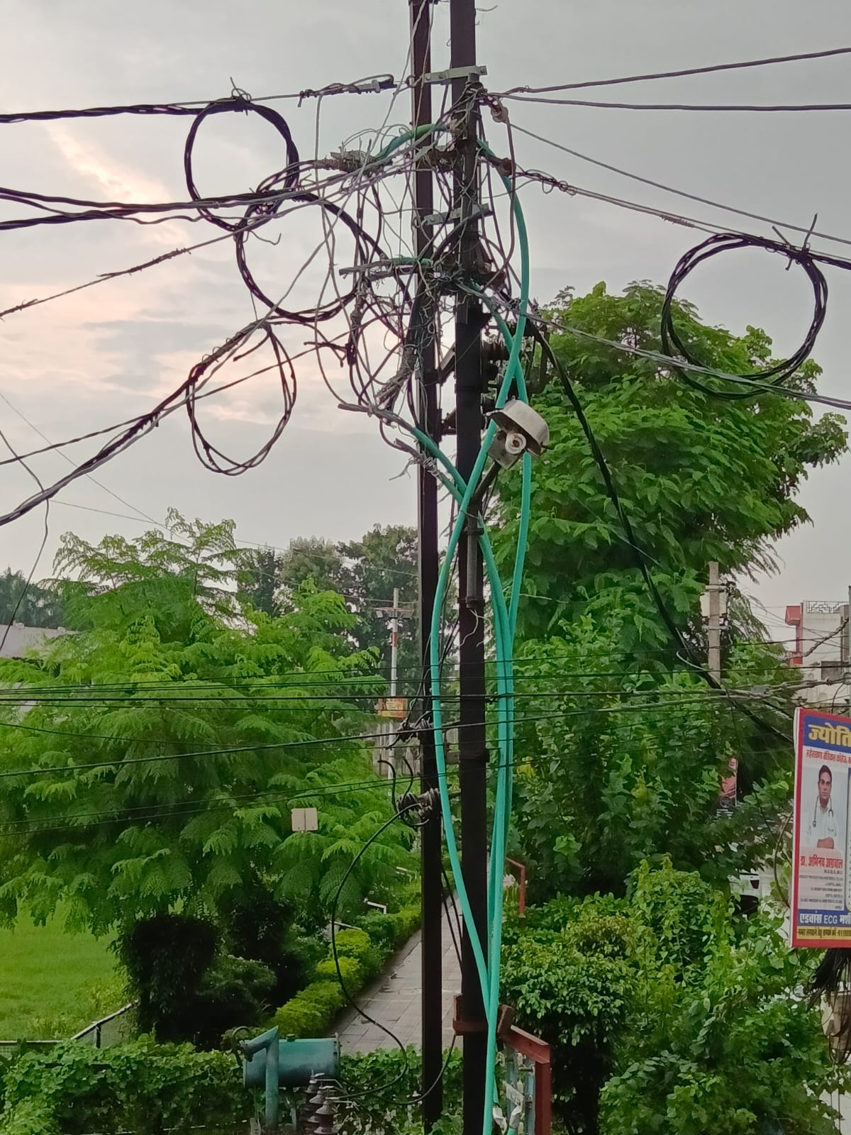 शहर की अशोक कॉलोनी में लगे खंभे पर फैला तारों का मकड़जाल। संवाद