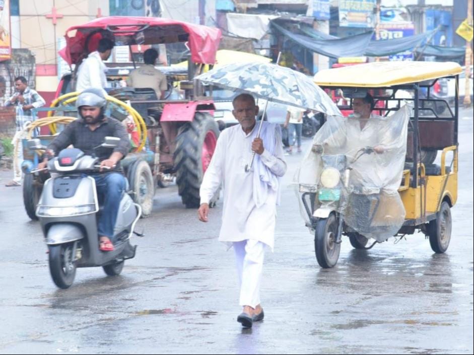 शामली में रिमझिम बारिश के दौरान जाते लोग। संवाद