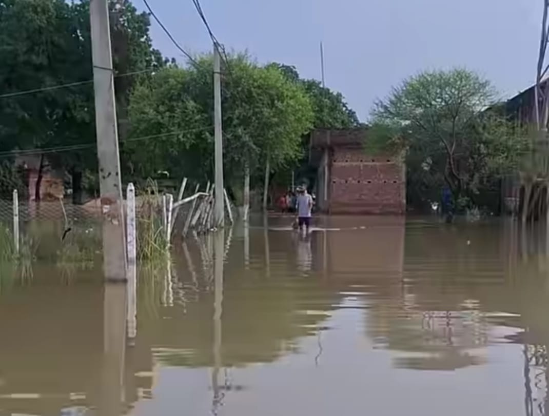 चौकी नौरंगा में नाव की कमी के चलते बाढ़ के पानी में आवागमन करते बाढ़ पीड़ित।संवाद