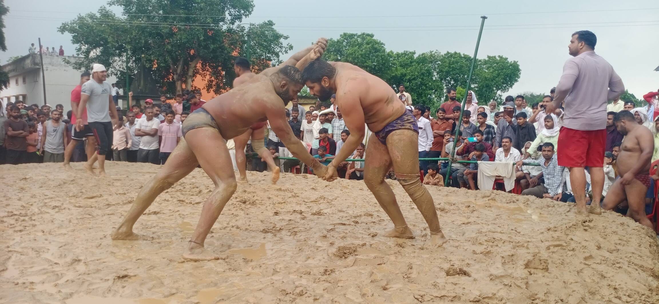 गुलड़िया के दंगल में जोर आजमाइश करते पहलवान। संवाद