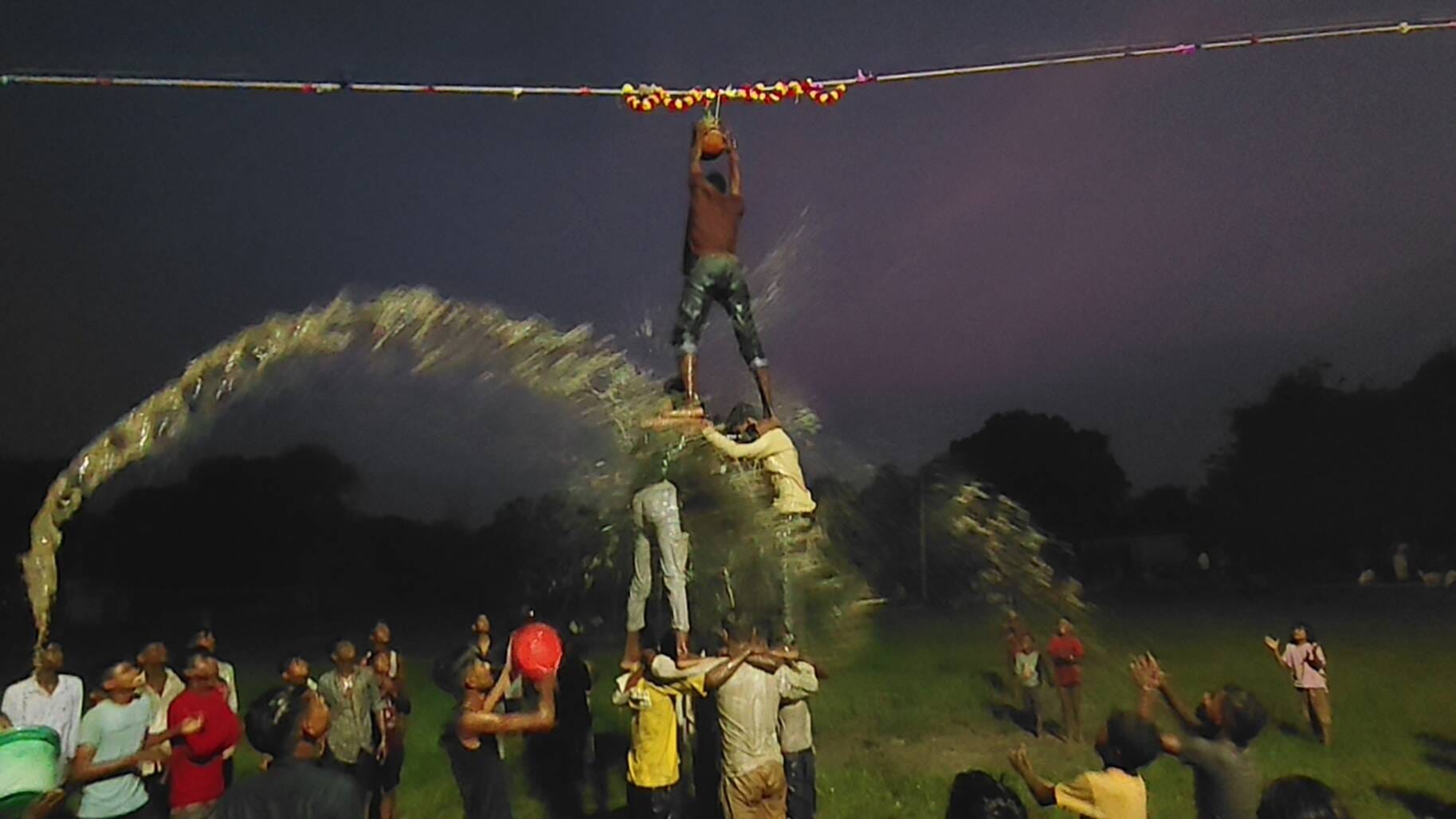 जमीन संदल गांव में चल रही प्रतियोगिता में मानव पिरामिड़ बनाकर दही हांडी फोड़ने का प्रयास करते य