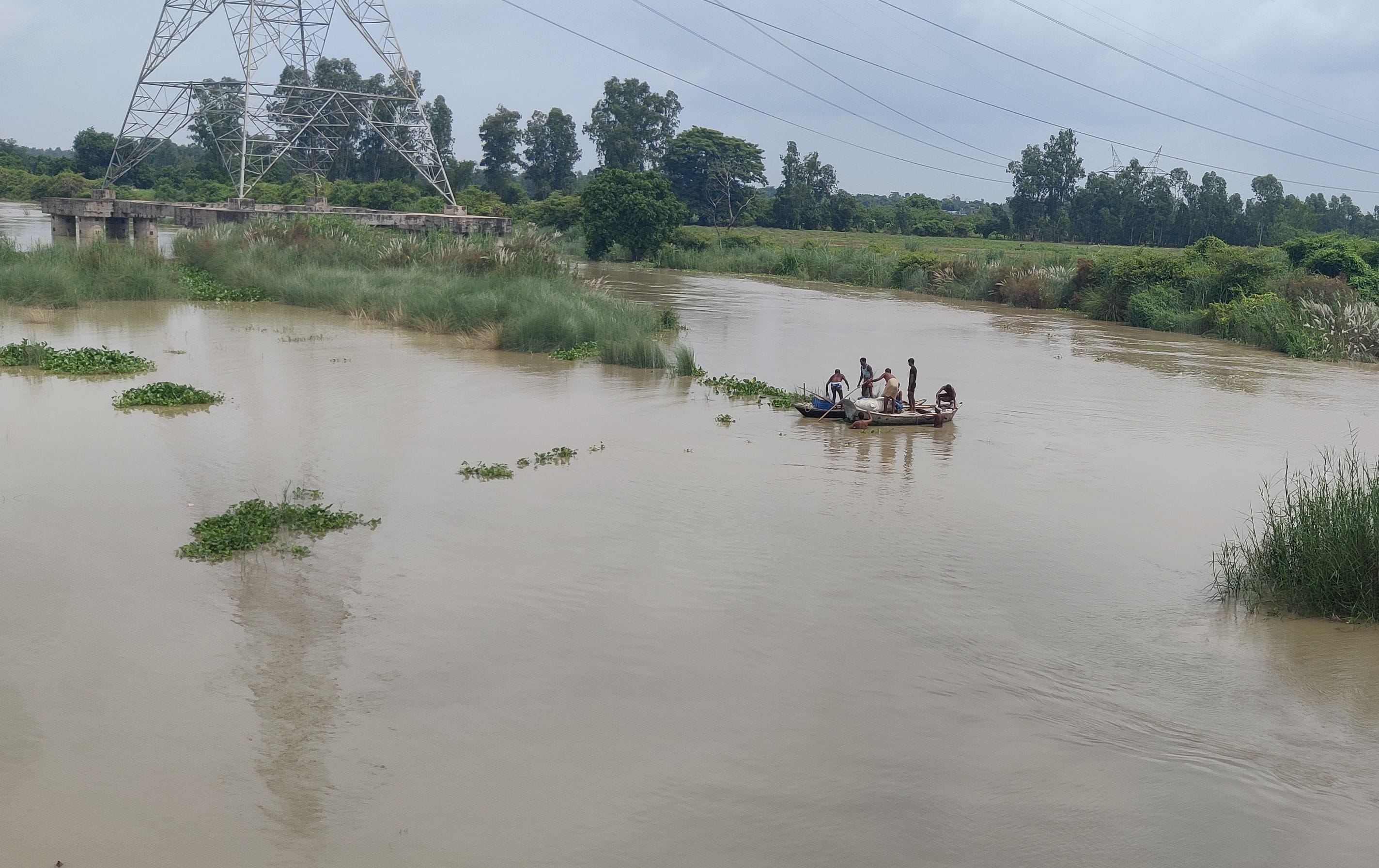 फोटो-31-देवीपुरवा क्षेत्र में पानी बढ़ने के बाद नाव के सहारे आवागमन करते ग्रामीण। संवाद