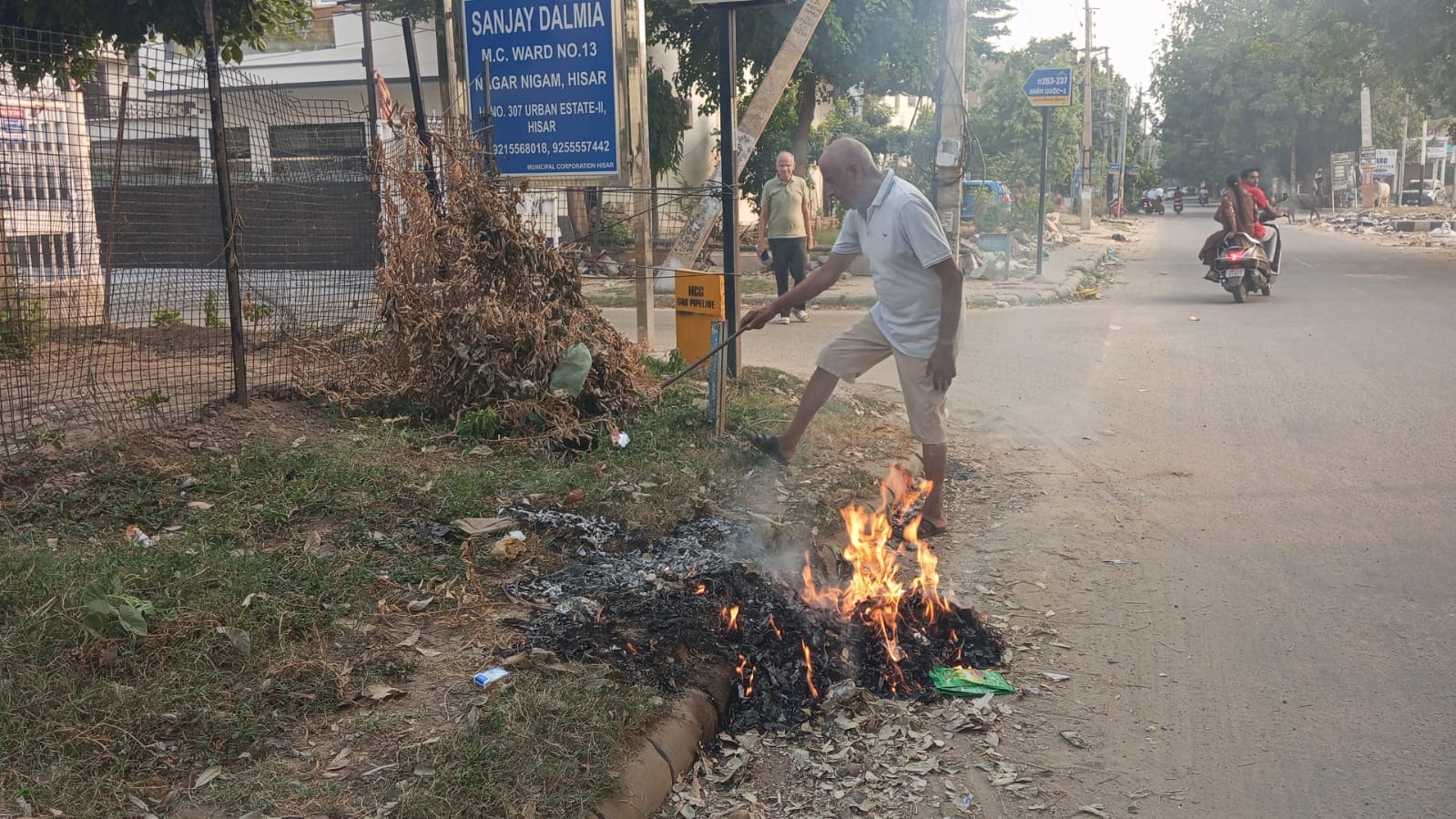 हिसार के अर्बन एस्टेट एरिया में कचरे में आग लगाते हुए बुजुर्ग।