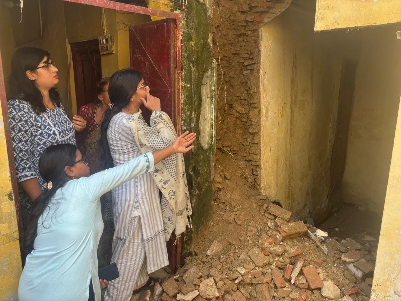 अनूपशहर में गंगा देवी राजकीय आयुर्वेदिक चिकित्सालय की गिरी दीवार को देखती चिकित्सव व कर्मचारी। 