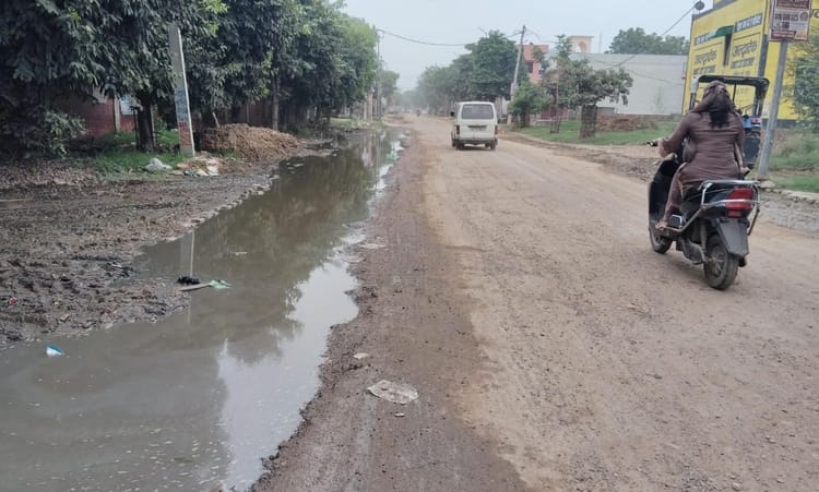 फोटो - बरोदा रोड पर भरे हुए पानी के पास से गुजरती हुई स्कूटी चालक। संवाद
