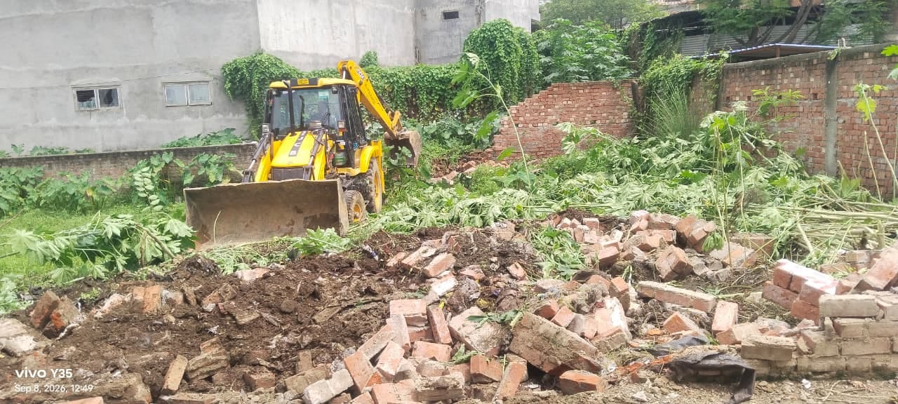 कब्जा ध्वस्त करती जेसीबी। 