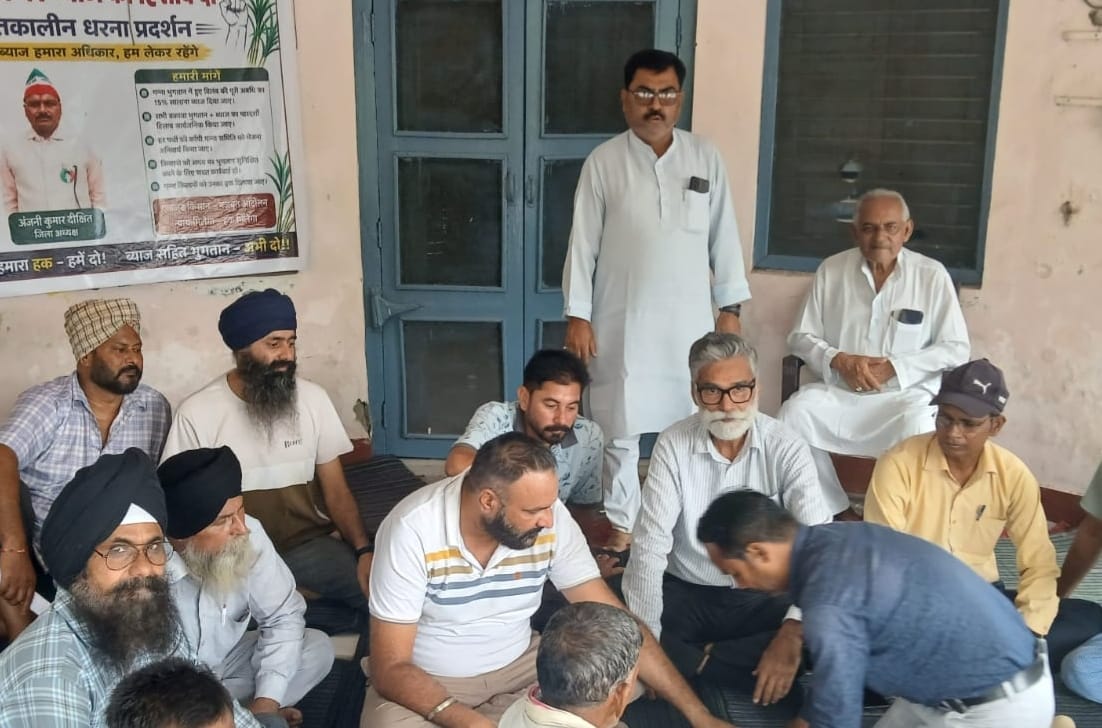 पलिया गन्ना समिति में धरने पर बैठे लोग। संवाद