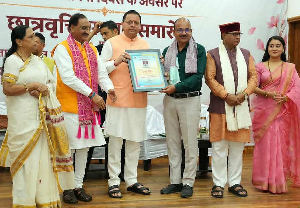 शिक्षक जमुना प्रसाद को सम्मानित करते सीएम पुष्कर धामी।