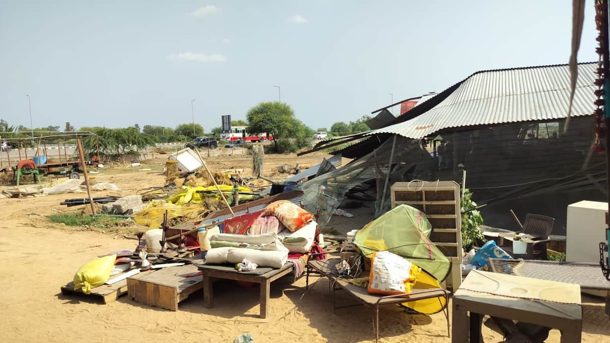 Bulldozer rolls over the *Nandishala*; the caretaker weeps with folded hands.