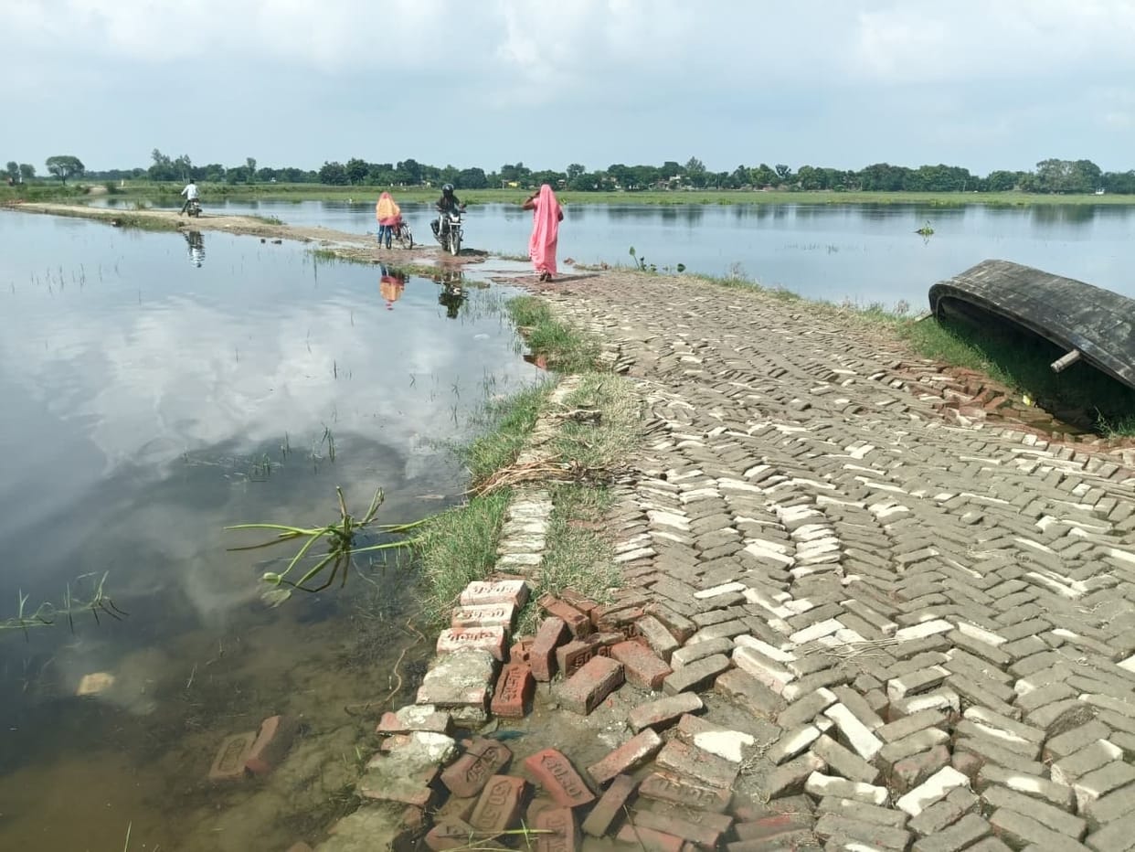 Access roads submerged by floods; children forced to use boats to get to school.