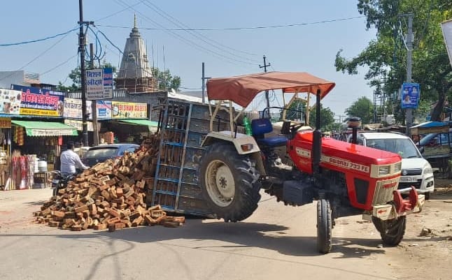 Tractor-trolley loaded with bricks overturns; people have a narrow escape.