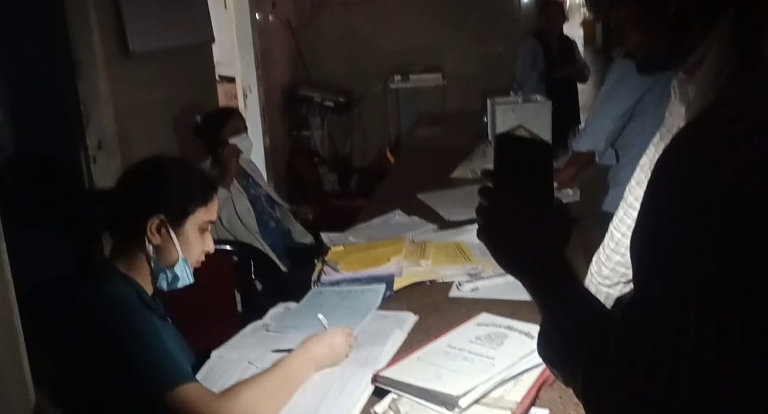 फोटो03ट्रामा सेंटर में बिजली गुल होने के बाद मोबाइल की रोशनी में पर्चे पर दवा लिखती महिला स