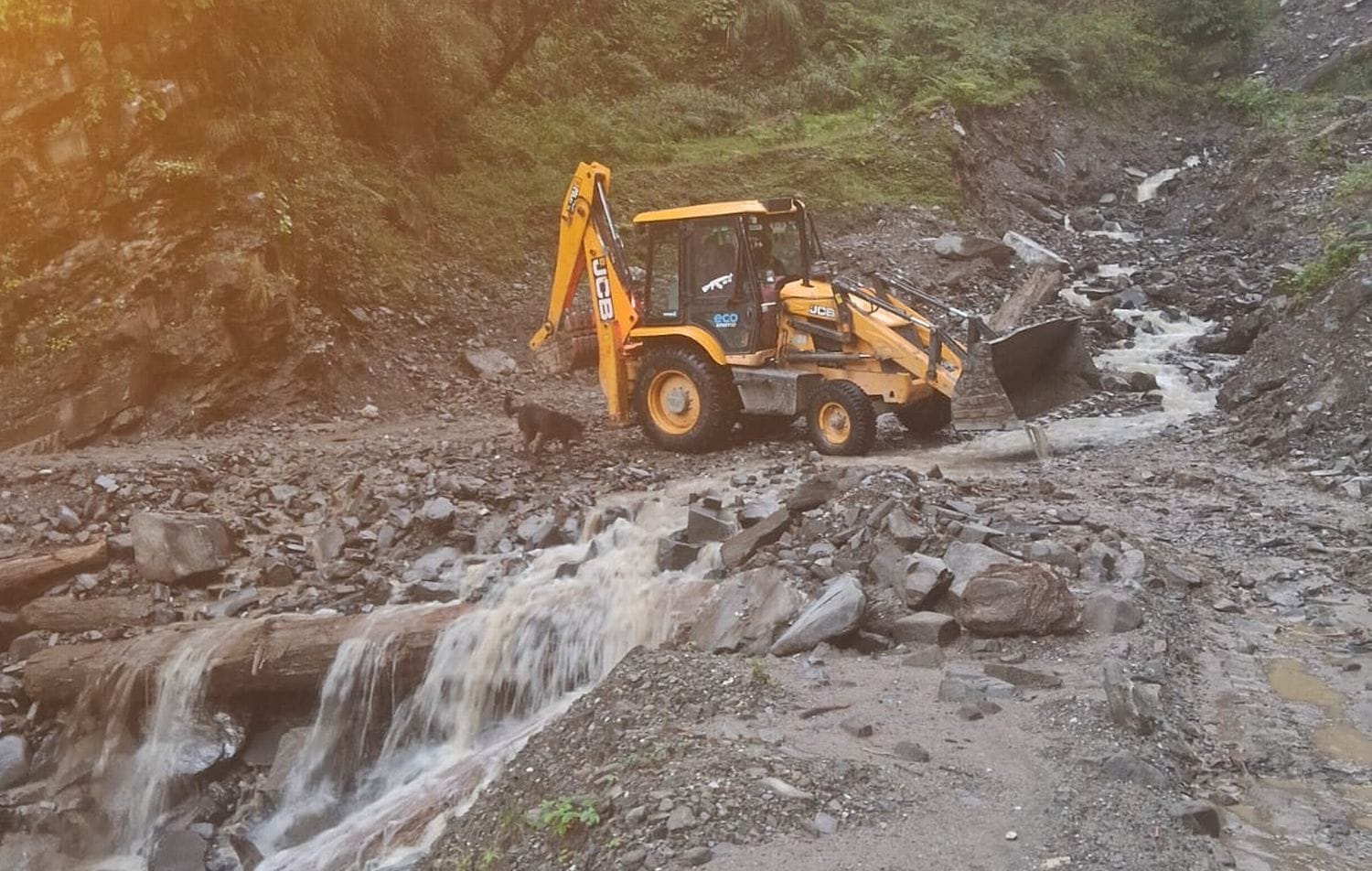 खनेरनाला में बाढ़ आने के बाद सड़क को बहाल करने में लगी जेसीबी। संवाद
