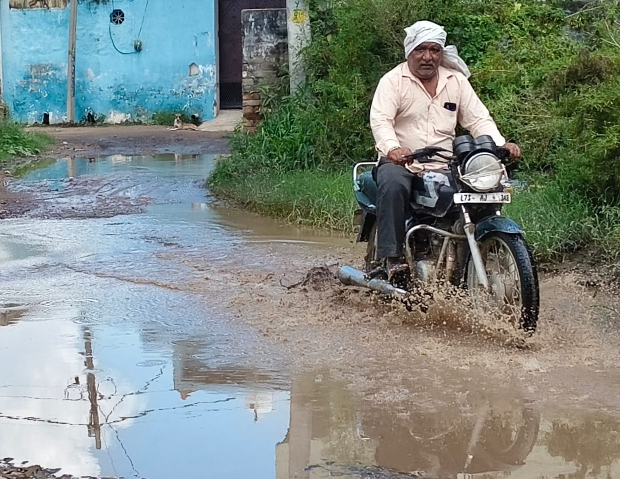 भुन्ना तगा गांव का मुख्य मार्ग बना तालाब, लोग जलभराव से परेशान, कीचड़ से निकलने को मजबूर।
