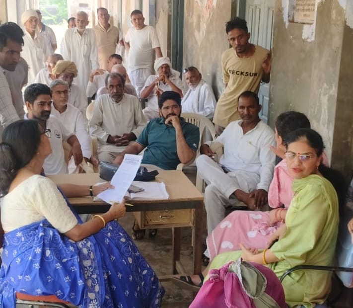 गांव धनाना में सरकारी स्कूल के पुराने कमरों की नीलामी रद्द करने के दौरान मौजूद ग्रामीण व अन्य। 