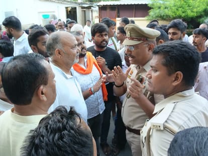 हंगामा करते लोगों को समझाती पुलिस
