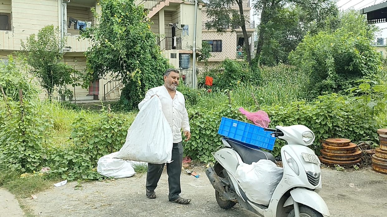 Garbage has not been collected from homes for months; the councilor is personally hauling away sacks on a scooter.