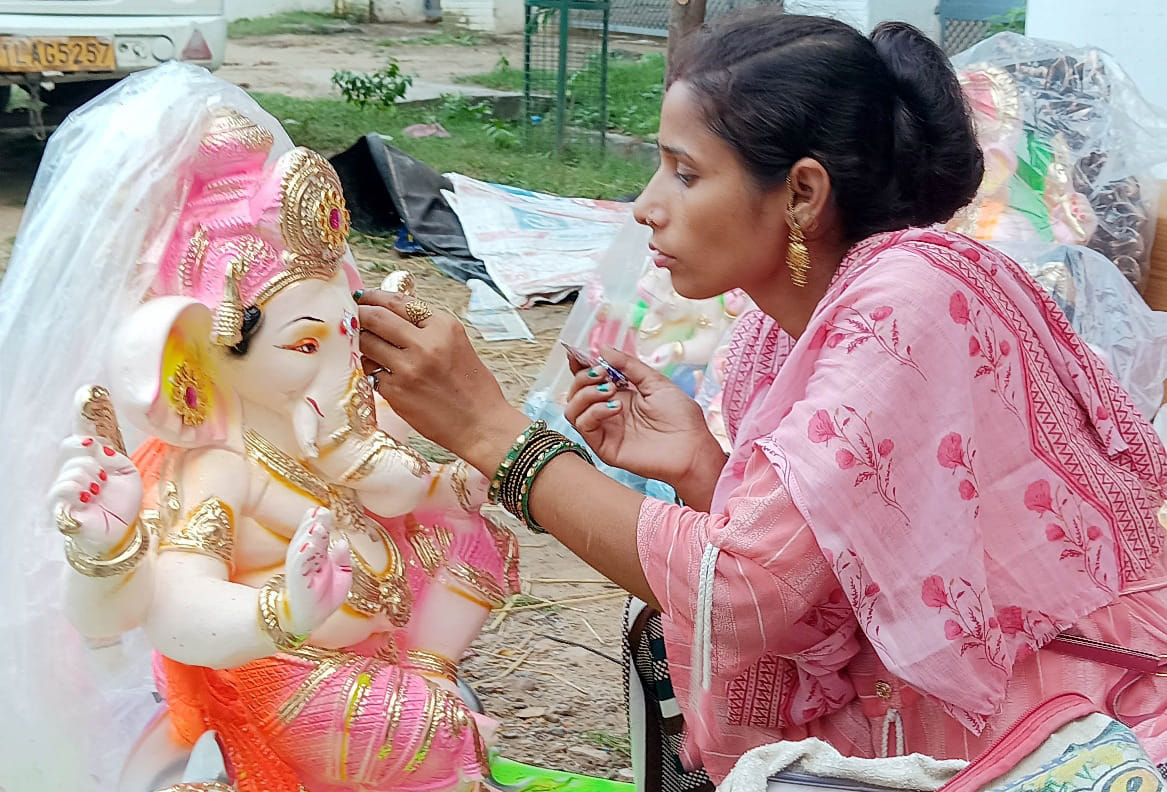 Ganesha idols sculpted; vibrant colors being applied.