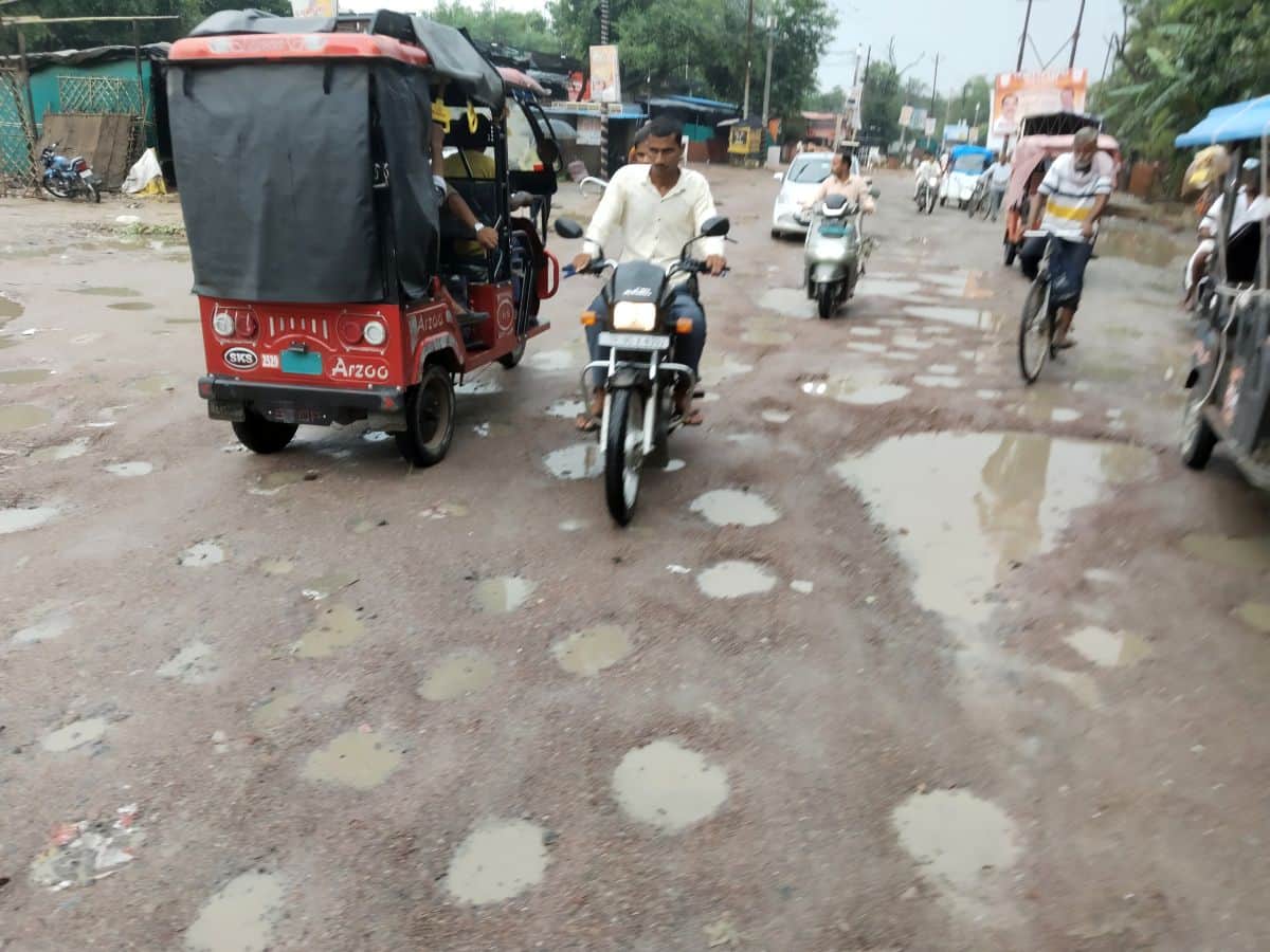 फोटो 12 एमएएचपी 14 परिचय-गड्ढों में तब्दील झलकारीबाई तिराहे से स्टेशन मार्ग की सड़क से गुजरते व