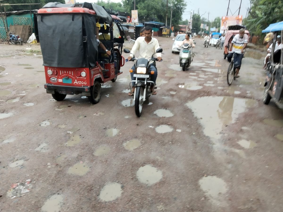 फोटो 12 एमएएचपी 14 परिचय-गड्ढों में तब्दील झलकारीबाई तिराहे से स्टेशन मार्ग की सड़क से गुजरते व