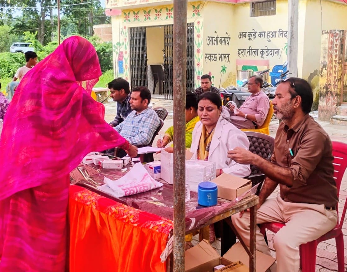 फोटो 18- मुंगूस गांव के पंचायत भवन में महिला का उपचार करते चिकित्सक। संवाद