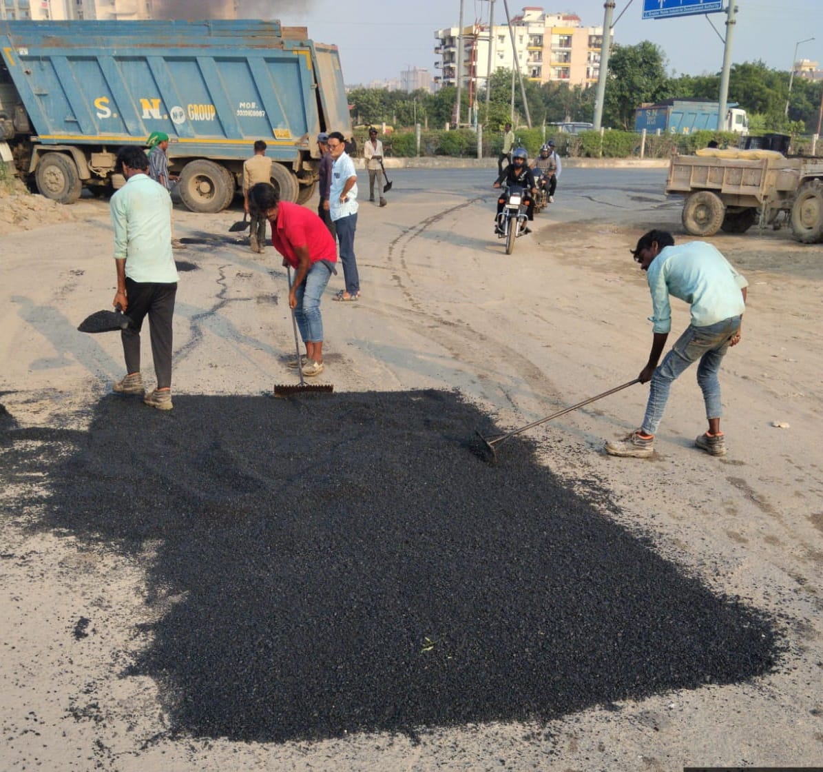 ग्रेटर नोएडा के जलपुरा में टूटी रोड को ठीक करते प्राधिकरण के कर्मचारी । स्रोत प्राधिकरण