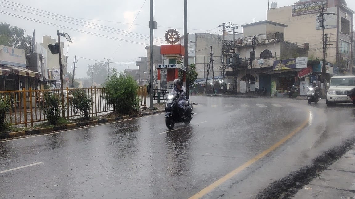 ऊना में तेज बारिश के बीच गंतव्य स्थान की ओर जाता दोपहिया चालक। संवाद