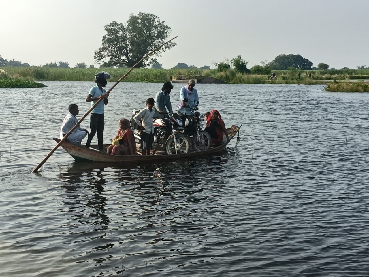 बेलहिया ढाला से नाव पर बाइक लादकर जाते ग्रामीण। संवाद