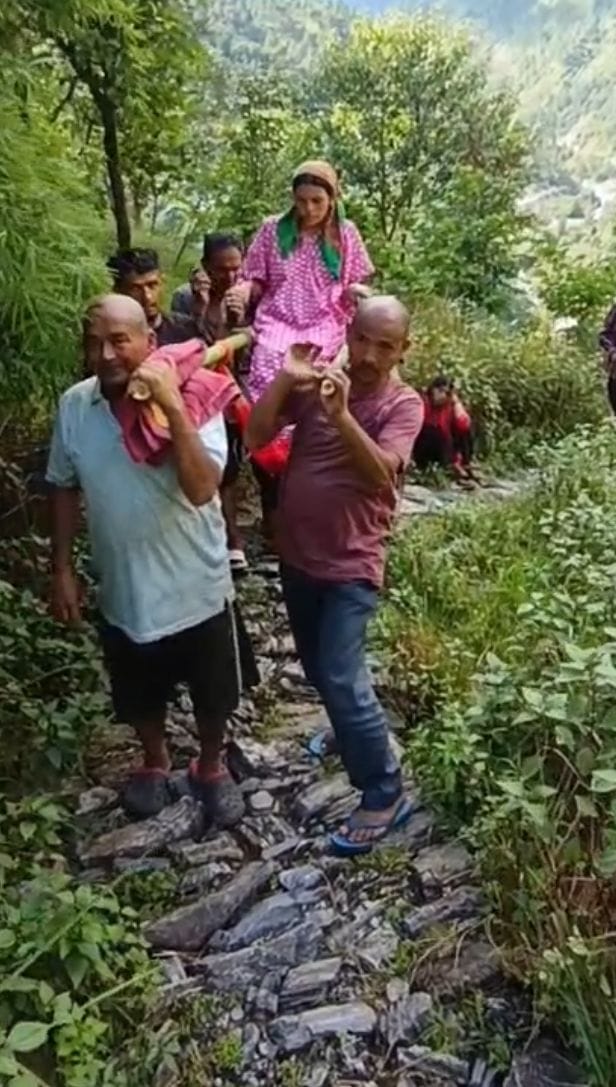 Protest enters 53rd day; villagers carry new mother home in a palanquin.