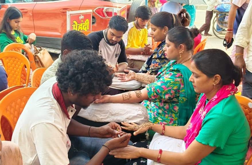 तीज पर्व की पूर्व संध्या पीडीडीयू नगर में मेंहदी लगवाती महिलाएं। संवाद