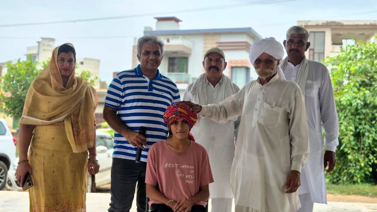 14जेएनडी03- संसद लाडो पंचायत में खुशी को पगड़ी बांधते हुए सुनील जागलान व सरपंच। स्रोत: ग्रामीण