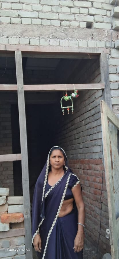 14jjrp14- मुंड़ाहेड़ा गांव में अधूरे पडे़ मकान को दिखाती महिला। स्रोत : ग्रामीण
