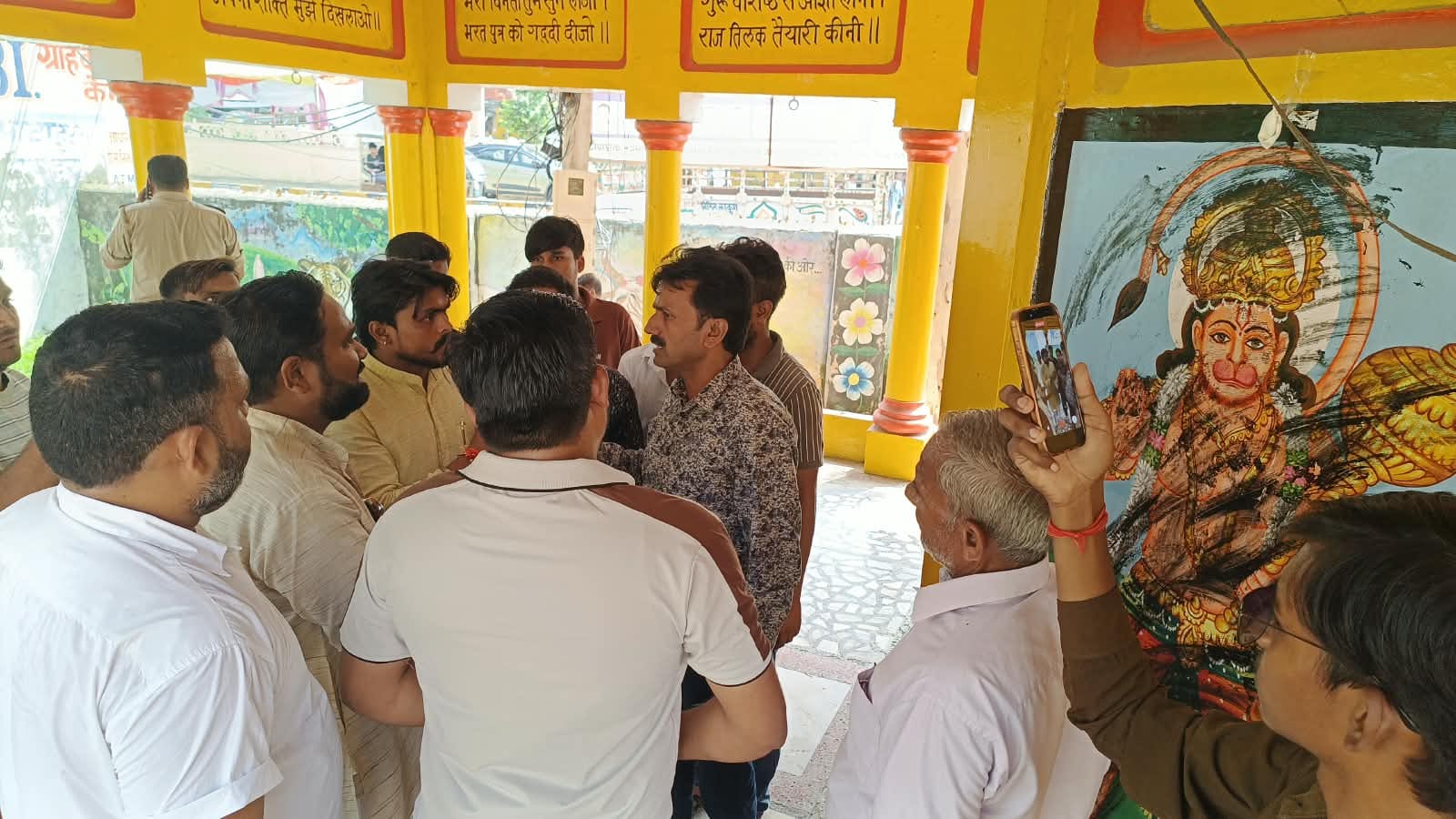 फोटो40नगर पालिका स्थित मंदिर में दैवीय चित्र पर काखिल पौते जाने के बाद आक्रोश जताते लोग।सं